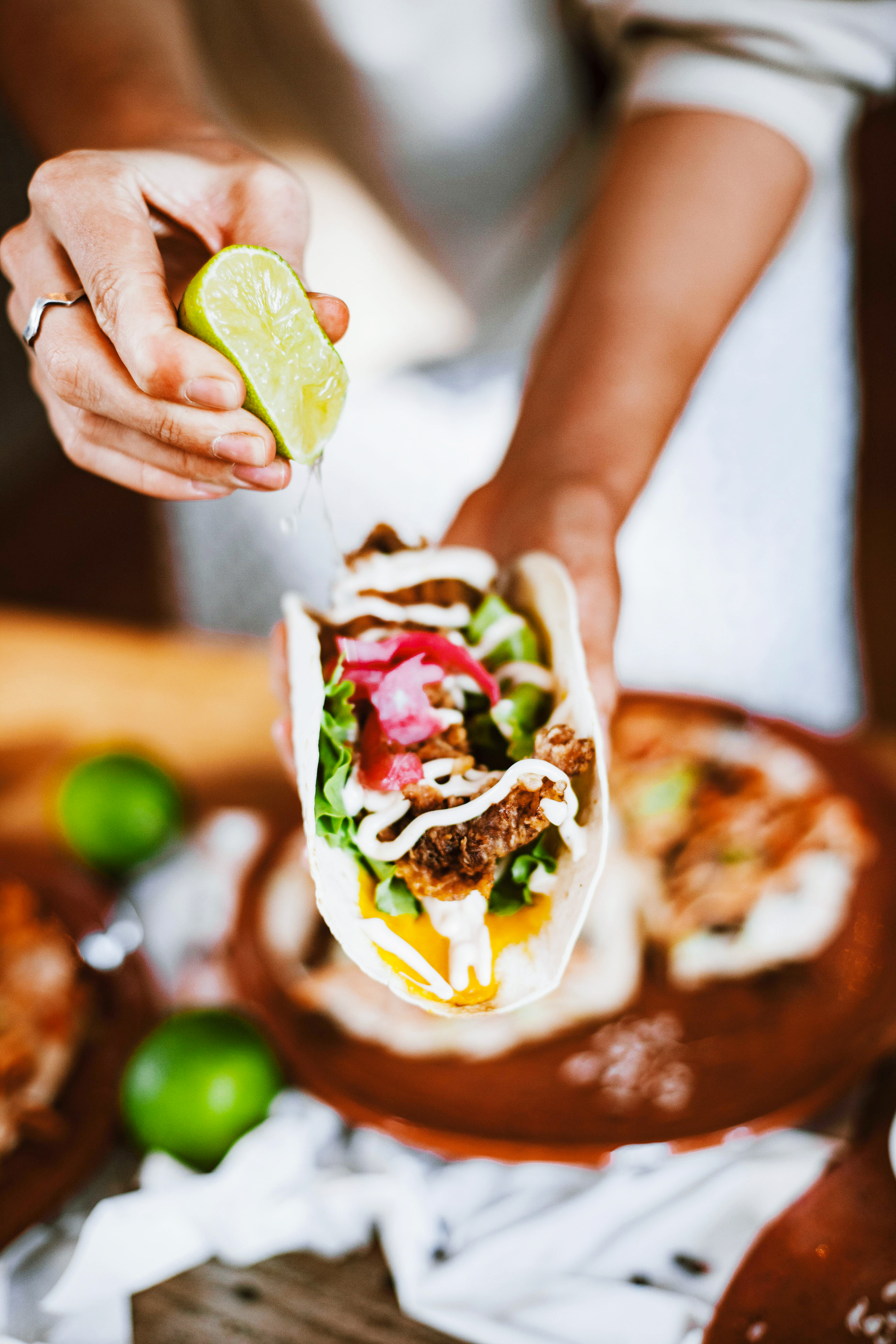 Hand holding a taco with various ingredients